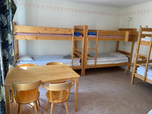 a room with two bunk beds and a table and chairs at Gefle vandrarhem in Gävle
