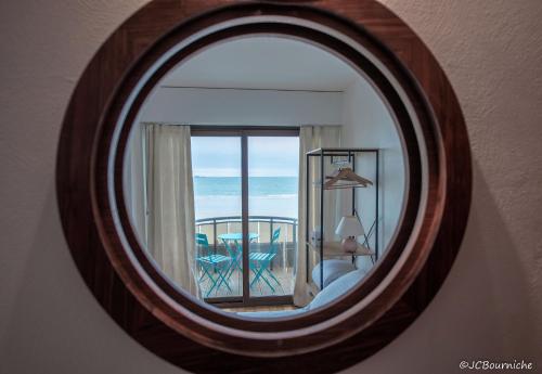 a mirror in a room with a view of the ocean at APPARTEMENT PLEINE VUE MER 34 Ch. du Sillon Saint-Malo Plage in Saint Malo