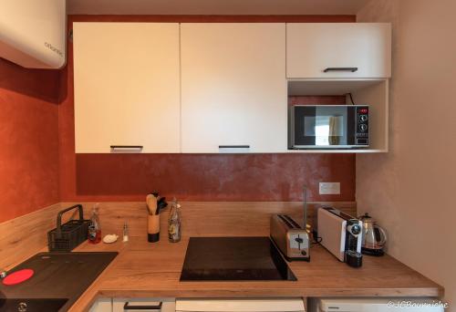 a kitchen with a counter top with a microwave at APPARTEMENT PLEINE VUE MER 34 Ch. du Sillon Saint-Malo Plage in Saint Malo