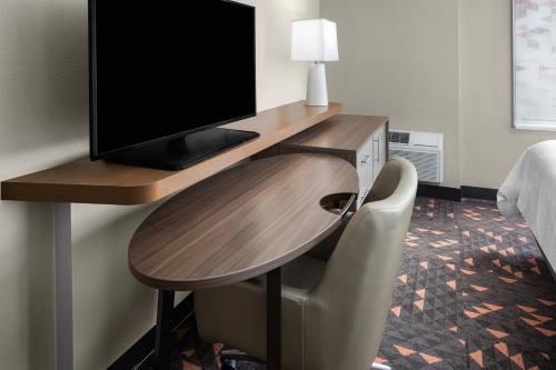 a desk with a television and a chair in a room at Holiday Inn Hasbrouck Heights-Meadowlands by IHG in Hasbrouck Heights