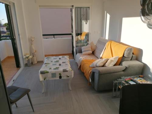 een woonkamer met een bank en een tafel bij Appartement moderne pour 6 adultes in Benalmádena