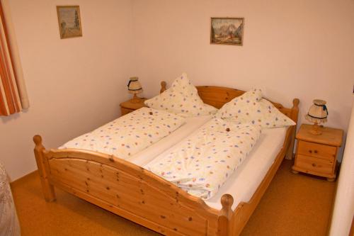 una camera con letto in legno e 2 comodini di Ferienwohnung Anner a Aschau im Chiemgau