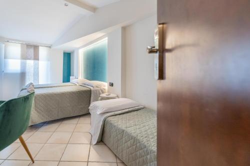 a small room with two beds and a window at Villa Rocla guest house Pompei in Pompei