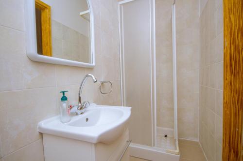 a white bathroom with a sink and a shower at Persephone Cottage by AgroHolidays in Platres