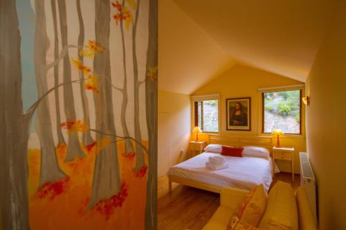 a bedroom with a bed and a tree mural at Persephone Cottage by AgroHolidays in Platres