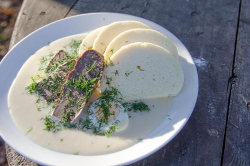 a plate of food with meat and vegetables on a table at Penzion a Bistro Dílna in Třeboň