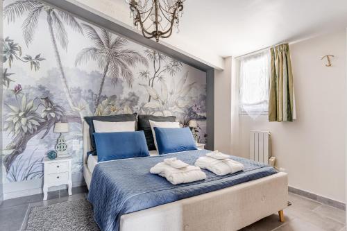 ein Schlafzimmer mit einem blauen Bett und Handtüchern darauf in der Unterkunft Le Parc in Carpentras