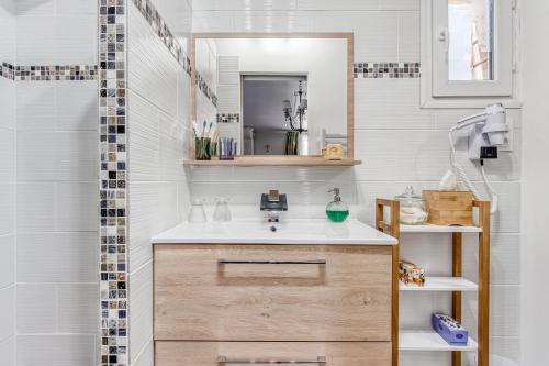 ein Bad mit einem Waschbecken und einem Spiegel in der Unterkunft Le Parc in Carpentras