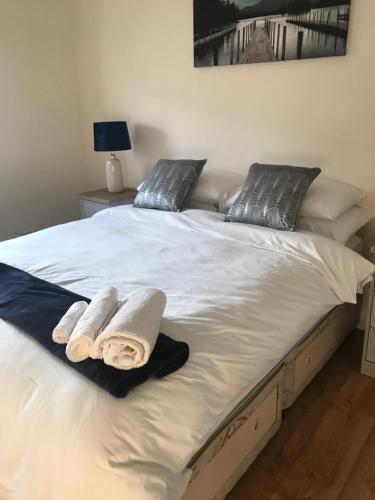 a large white bed with two towels on it at Ard Cashel in Dungloe