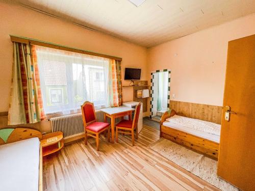 1 dormitorio con cama, escritorio y ventana en Vural Rooms, en Gmünd