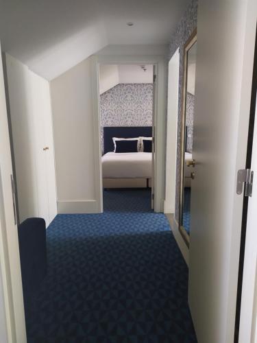 a hallway with a bed in a room with blue carpet at Hotel Lis Baixa in Lisbon