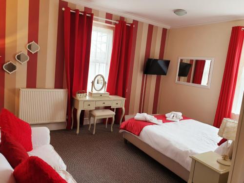 a bedroom with two beds and a desk with a mirror at Preston Hotel in Yeovil