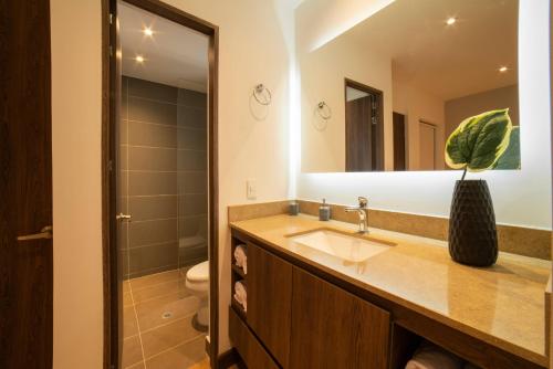 a bathroom with a sink and a mirror at Cali River Suites by Yellowkey Capital in Cali