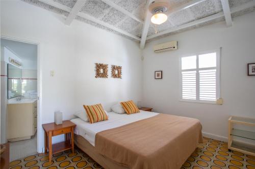 une chambre blanche avec un lit et une fenêtre dans l'établissement Bungalow Seabass, à Willemstad
