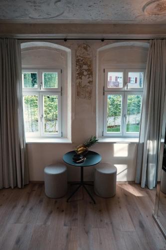 a room with a table and two windows at Gartenhäuschen by Hotel Goldene Rose in Dinkelsbühl