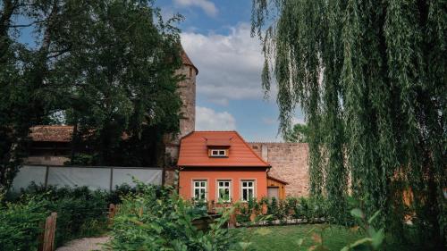 丁克爾斯比爾的住宿－Gartenhäuschen an der Wörnitz，建筑前有红色屋顶的房子