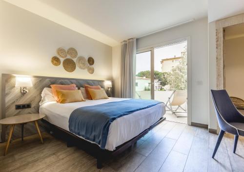 a bedroom with a large bed and a balcony at 1935 Hotel Boutique by Terraza in Roses