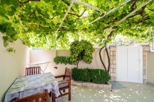 a patio with two chairs and a table and a tree at Guest House Vulić in Dubrovnik