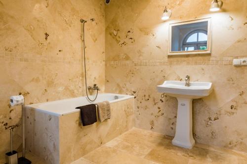 a bathroom with a sink and a tub and a toilet at Pokoje gościnne przy Rynku in Dąbrówno