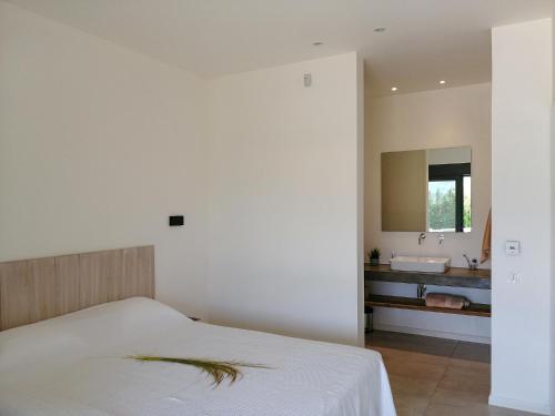 a bedroom with a bed and a bathroom with a sink at Villa Aetos in Paleros