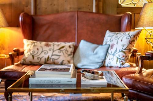 a coffee table with books on top of a couch at Villa Zollhaus Bed & Breakfast in Türkheim