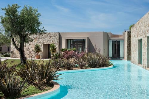 une piscine devant une maison dans l'établissement Baglioni Resort Sardinia - The Leading Hotels of the World, à San Teodoro
