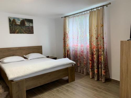a bedroom with a bed and a window at Casa Anna&Criss in Orşova