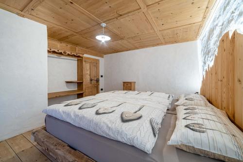 1 dormitorio con 1 cama con 2 almohadas en Ospitalità Diffusa Laste Dolomites - Cèsa del Bepo Moro, en Colle Santa Lucia