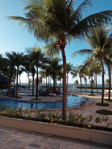 un complejo con palmeras y piscina en Kariri Beach Apartamento inteiro, Cumbuco, Fortaleza, en Cumbuco
