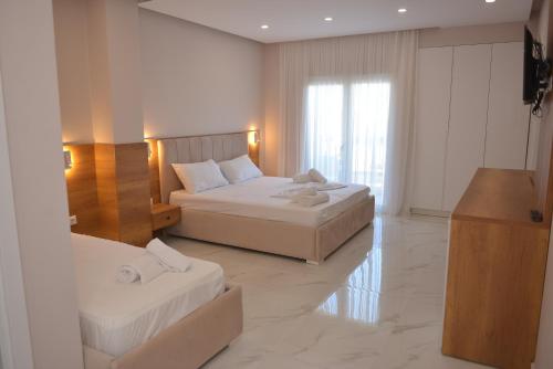 a hotel room with two beds and a television at Hotel Margjokaj in Velipojë