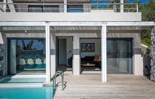 a house with a swimming pool and a wooden deck at Villa Aetos in Paleros