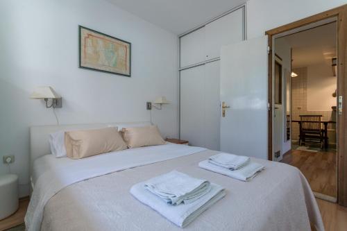 Un dormitorio con una cama blanca con toallas. en Best Apartment Roxy, en Dubrovnik