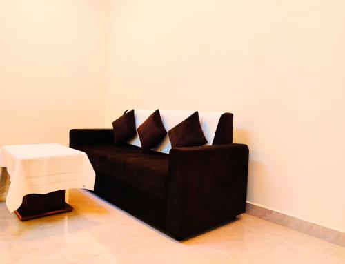 a black couch in a room with a table at THAAI RESIDENCY in Tiruvannāmalai