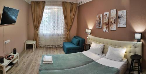 チェルニウツィーにあるApart Club Dzhambulaのベッドルーム1室(ベッド1台、青い椅子付)