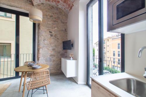 a kitchen with a table and a large window at Caelus Boutique Studio in Girona