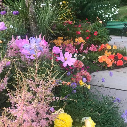 a garden with colorful flowers and a bench at Castlecroft Bed and Breakfast in Stirling