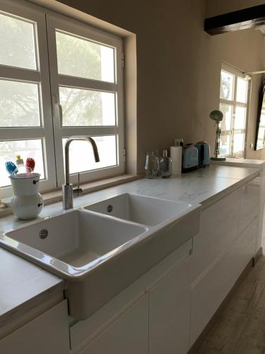 a large white sink in a kitchen with a window at Casa Paloma in Comporta