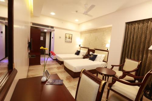 a hotel room with a bed and a dining table at The One Hotel in Aurangabad