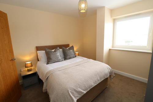 um quarto com uma cama com duas almofadas e uma janela em The Retreat - IH21ALL - APARTMENT 6 em Thornaby on Tees