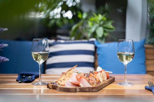 two glasses of wine and a plate of food on a table at Harbour Hotel in Galway