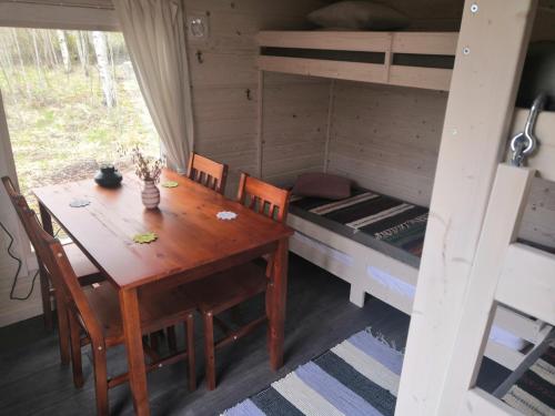 a dining room with a table and a bunk bed at Mäentaustan aitat in Janakkala