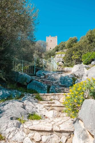 a castle on top of a hill with rocks at BILOCALE CON VISTA MARE E TERRAZZA PANORAMICA Ammentos Posada in Posada