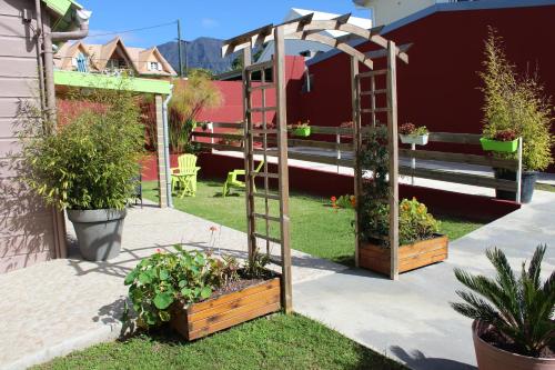 a garden with a gazebo and potted plants at CASAMELIAS Le chalet in Cilaos