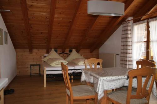 ein Esszimmer mit einem Bett, einem Tisch und Stühlen in der Unterkunft Ferienwohnungen Dananic in Anger