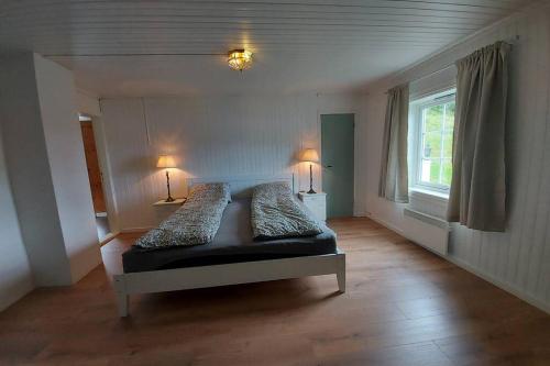 een slaapkamer met een bed met 2 kussens en 2 lampen bij A quiet and a relaxing place to stay in Mittet