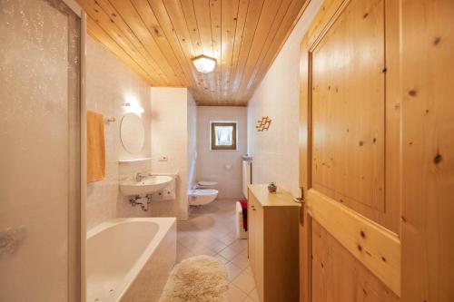 サレンティーノにあるWieserhof Ferienwohnung Zirmのバスルーム(バスタブ、洗面台、トイレ付)