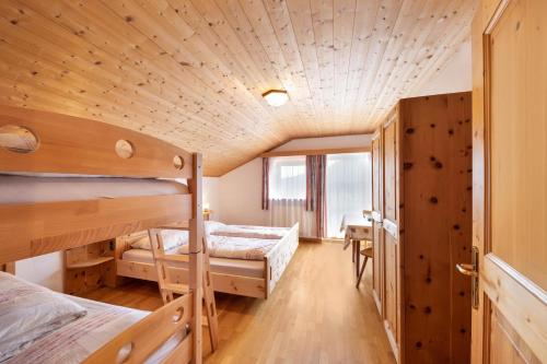 a dorm room with two bunk beds and a window at Wieserhof Ferienwohnung Zirm in Sarntal