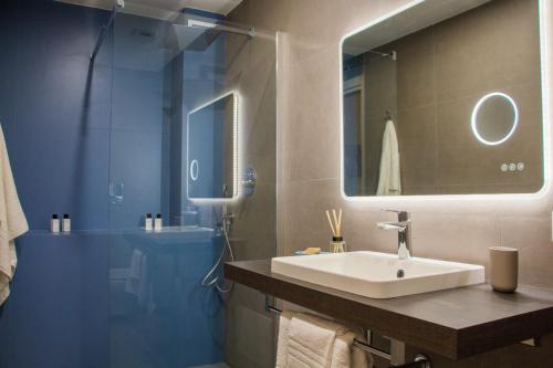 a bathroom with a sink and a shower with a mirror at Blue Plebiscito in Naples