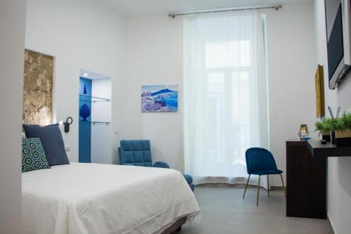 a bedroom with a bed and two blue chairs at Blue Plebiscito in Naples
