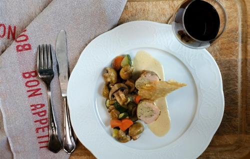 a plate of food with vegetables and a glass of wine at Château Saint Gilles - Bayeux in Guéron